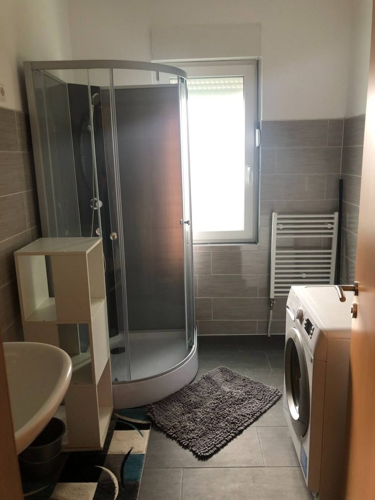 Ein Badezimmer mit Dusche und Waschmaschine